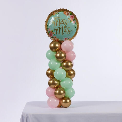 Mint, pink and gold tabletop balloon column with a round “Miss to Mrs” foil topper.