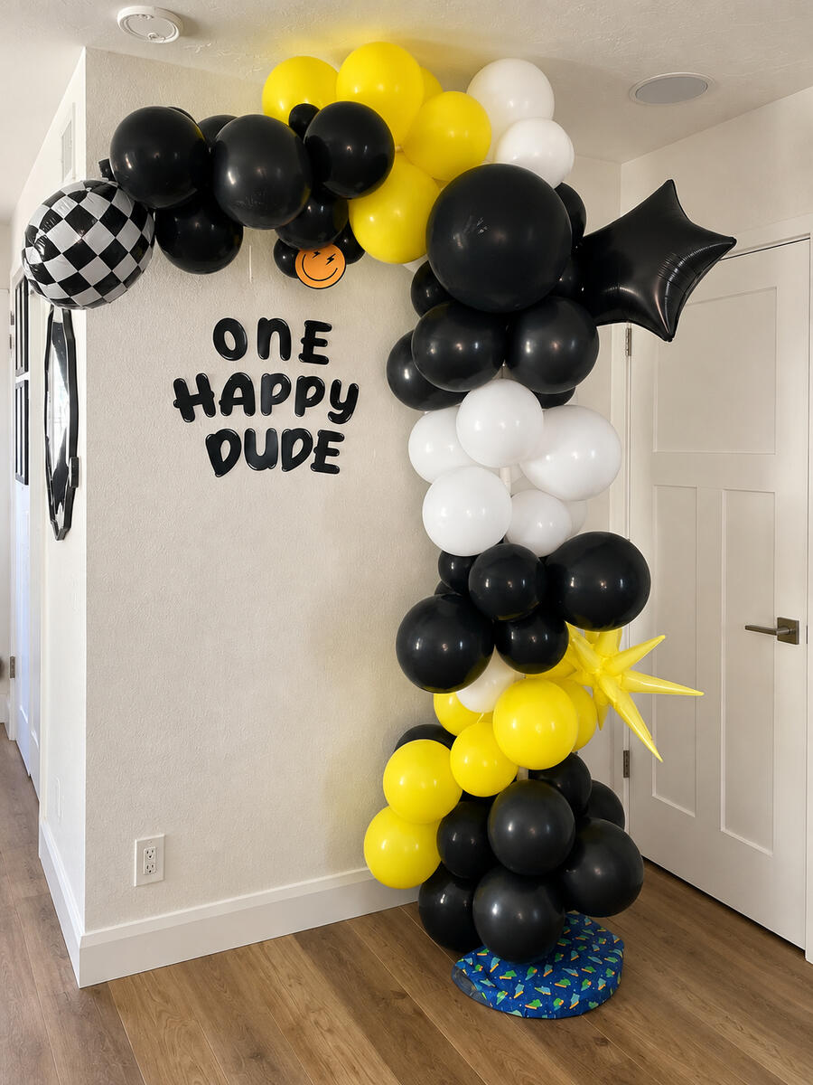 Black, white and yellow balloon half-arch with checkerboard and star accents; earlier work by Joshua.